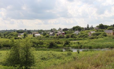 Tanawin ng mga bahay sa gitna ng bush malapit sa isang ilog sa Minnedosa