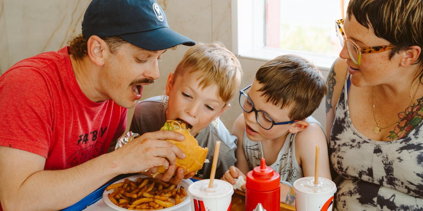 Shoestring French Fries In White Paper Bag On Picnic Table Stock