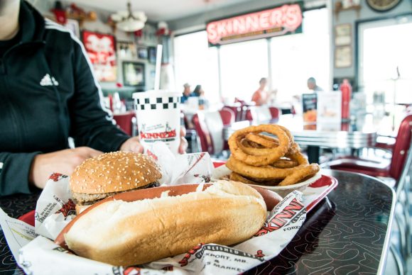 pagkain sa kainan sa mesa mula sa mga skinner. hamburger, hotdog, at onion ring na may tasa ng inumin mula sa mga skinner sa manitoba canada