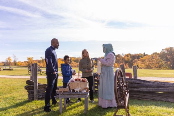 Eine Familie im Gespräch mit einem kostümierten Dolmetscher im Lower Fort Garry