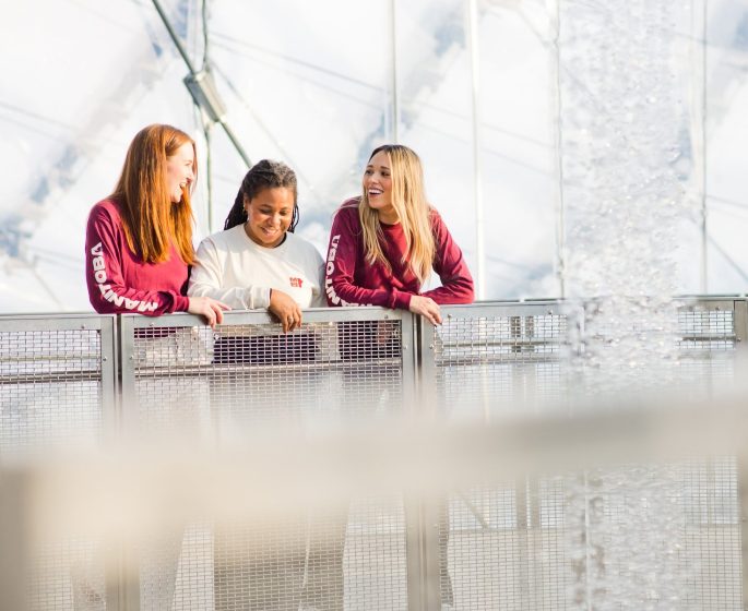 Tres personas explorando The Leaf con la nueva equipación de Manitoba: camiseta roja de manga larga, sudadera de color crema.