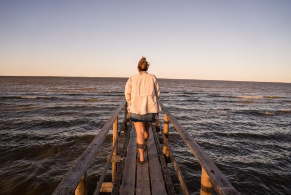 Taong naglalakad palabas sa pier sa ibabaw ng Lake Winnipeg sa Matlock Beach