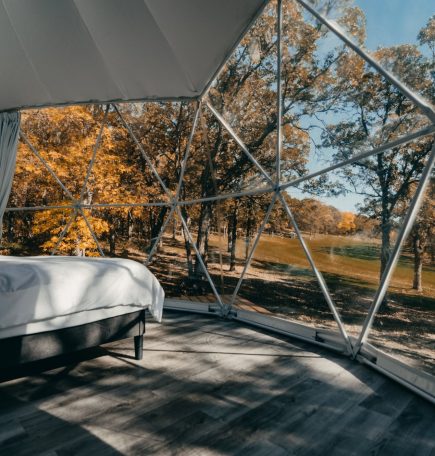 Mirando a través de las amplias ventanas desde el interior de una cabaña de cúpula geodésica en Moonlit Canopies.