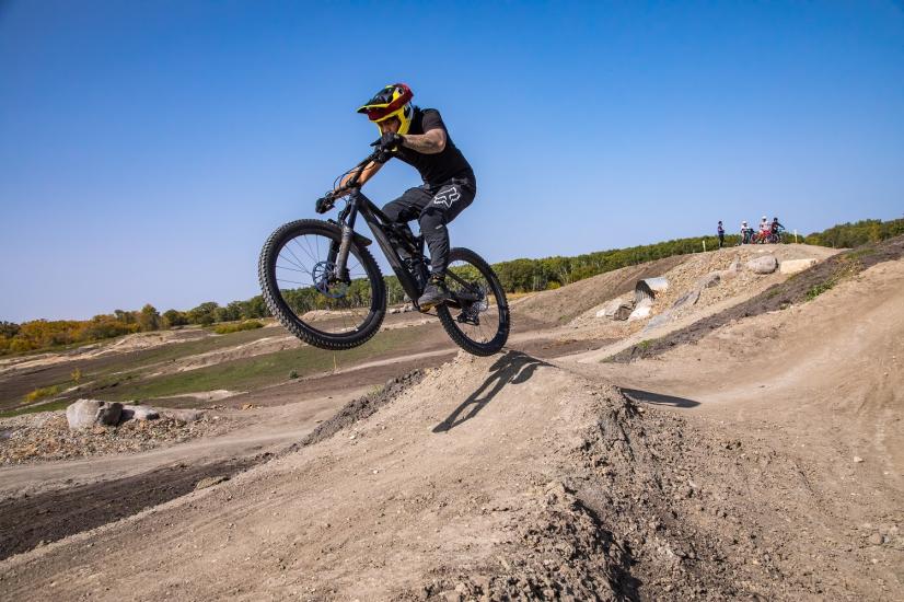 Ein Mountainbiker macht einen Sprung auf der Neepawa Hylife Back Forty Sprungbahn.