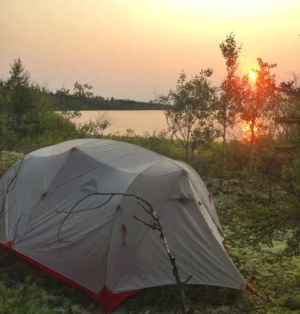 Una tienda junto a un lago al atardecer en el norte de Manitoba.