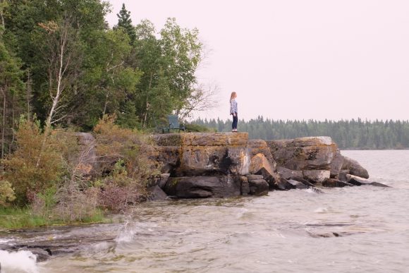 Taong nakatayo sa isang bato kung saan matatanaw ang Rocky Lake