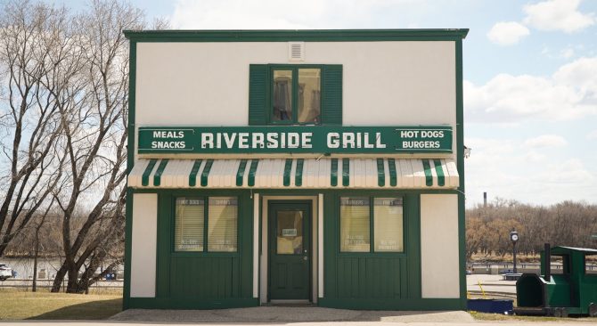 Toldo verde y blanco y edificio del Riverside Grill en Selkirk.