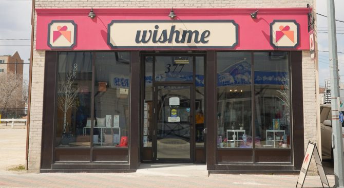 Fachada blanca de Wishme con un toldo rojo, en el centro histórico de Selkirk.