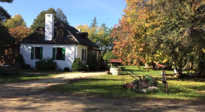 Exterior view of a white house surrounded by a treed yard at Thomas Bunn House