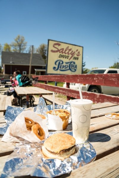 Burger und Zwiebelringe an einem Picknicktisch vor Salty's in Winnipeg Beach