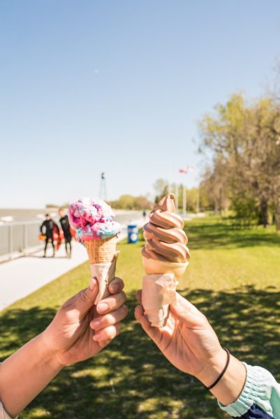 Zwei Personen halten Eiswaffeln in Winnipeg Beach hoch