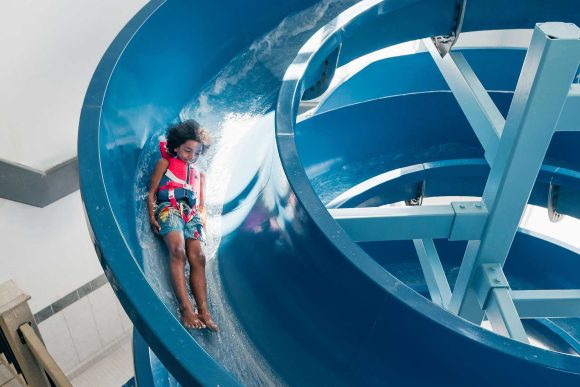 Batang dumudulas sa isang liko sa water slide sa Days Inn Steinbach.