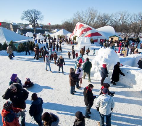 Des personnes découvrent les sculptures de glace et les animations du Festival du Voyageur, qui se déroule en plein air.