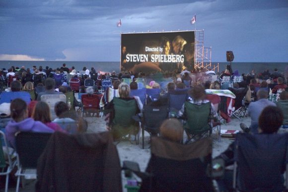 Während des Gimli Film Festivals versammelt sich eine Menschenmenge am Strand von Gimli, um einen Film auf der großen Leinwand zu sehen.