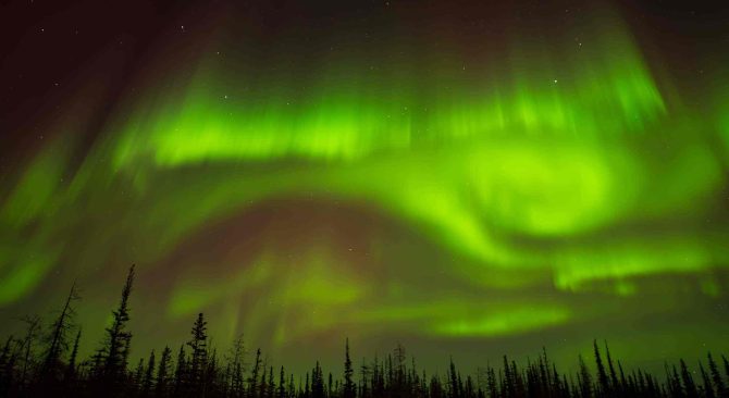 Leuchtend grüne Wirbel von Nordlichtern in Churchill.