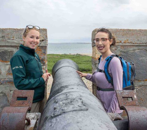 Two people pose with a canon at the Prince of Wales Fort in Churchill.