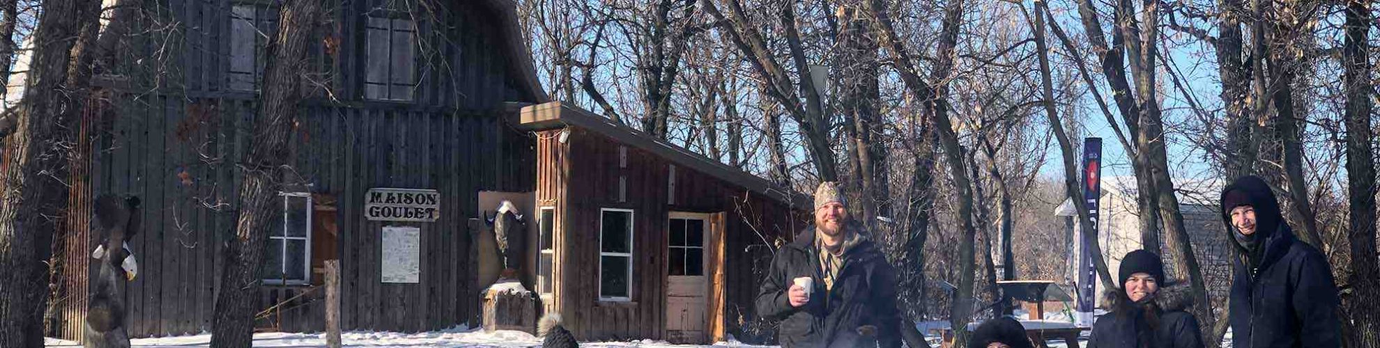 Un grupo de personas asando malvaviscos alrededor de la hoguera tras una tarde de raquetas de nieve.