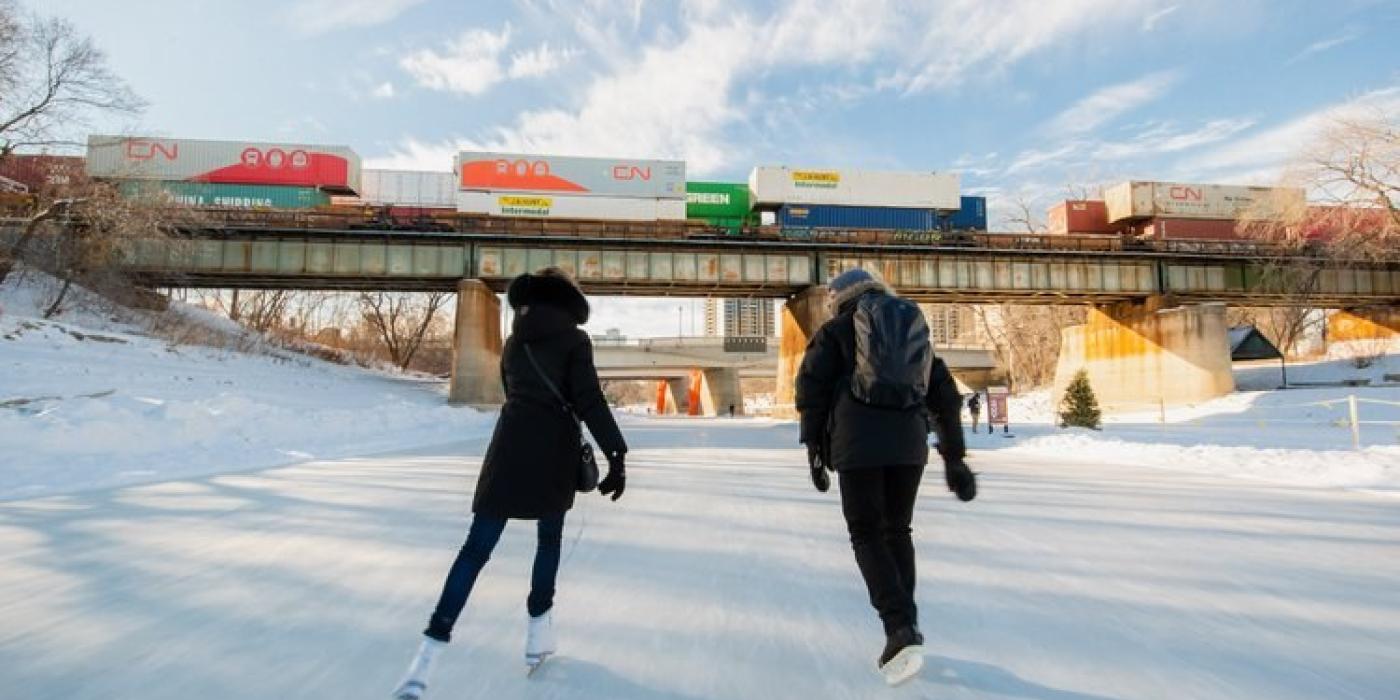Two people skating on the Red River Mutual Trail at The Forks.