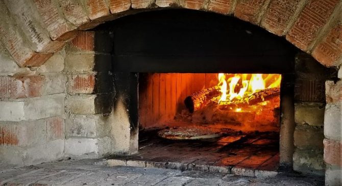 Pagluluto ng pizza sa isang brick wood-fired pizza oven.
