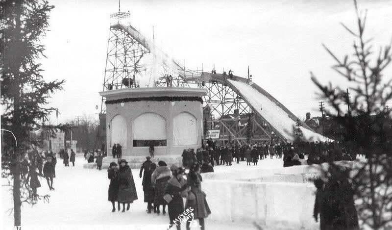 Black and white image of people lining up to ride an old toboggan slide at The Forks in the 1920s.